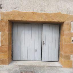 Vue du garage avec l'enduit appliqué autour de la porte, en façade