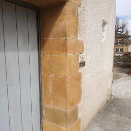 Vue du garage avec l'enduit appliqué autour de la porte, en façade